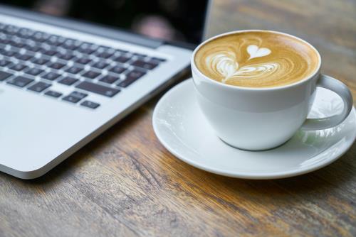 A laptop and coffee to show a business meeting 